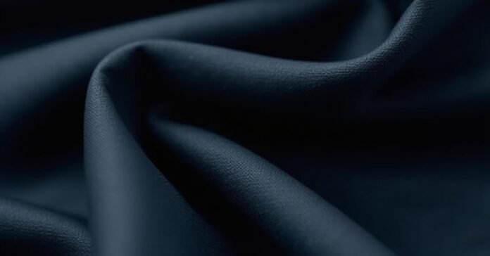 Smooth folds of dark blue rayon fabric, raising the question: is rayon a natural fiber?