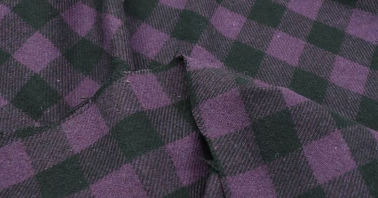 Close-up of cotton flannel fabric with a purple and green plaid pattern, answering "What is cotton flannel fabric."