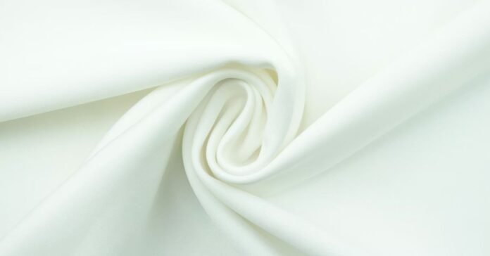 A close-up of white milk silk fabric, showing its smooth texture.