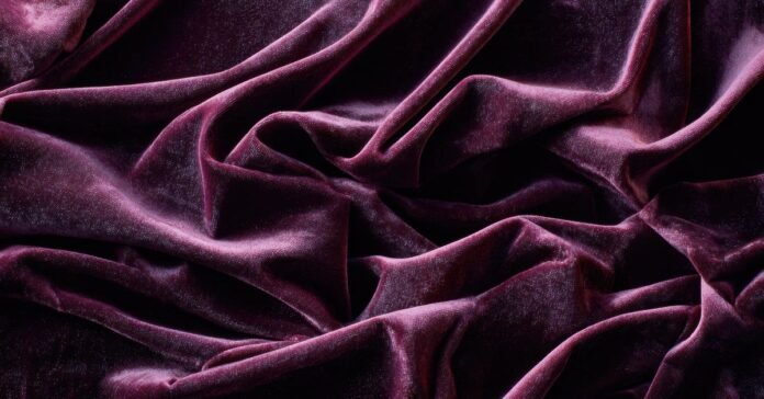 Close-up of rich, purple velvet fabric with folds and textures. What is velvet fabric?