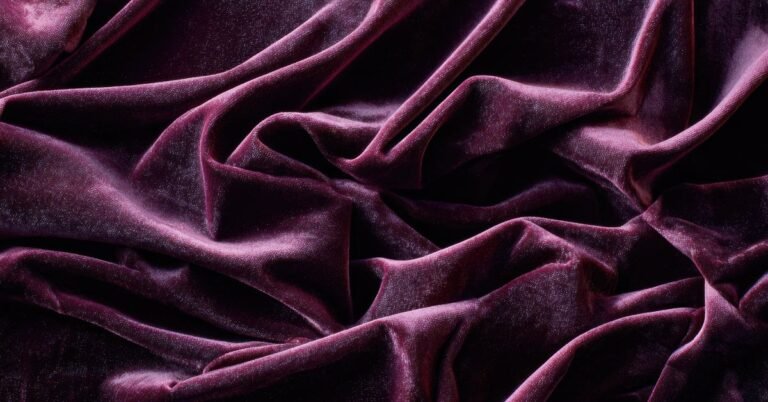 Close-up of rich, purple velvet fabric with folds and textures. What is velvet fabric?