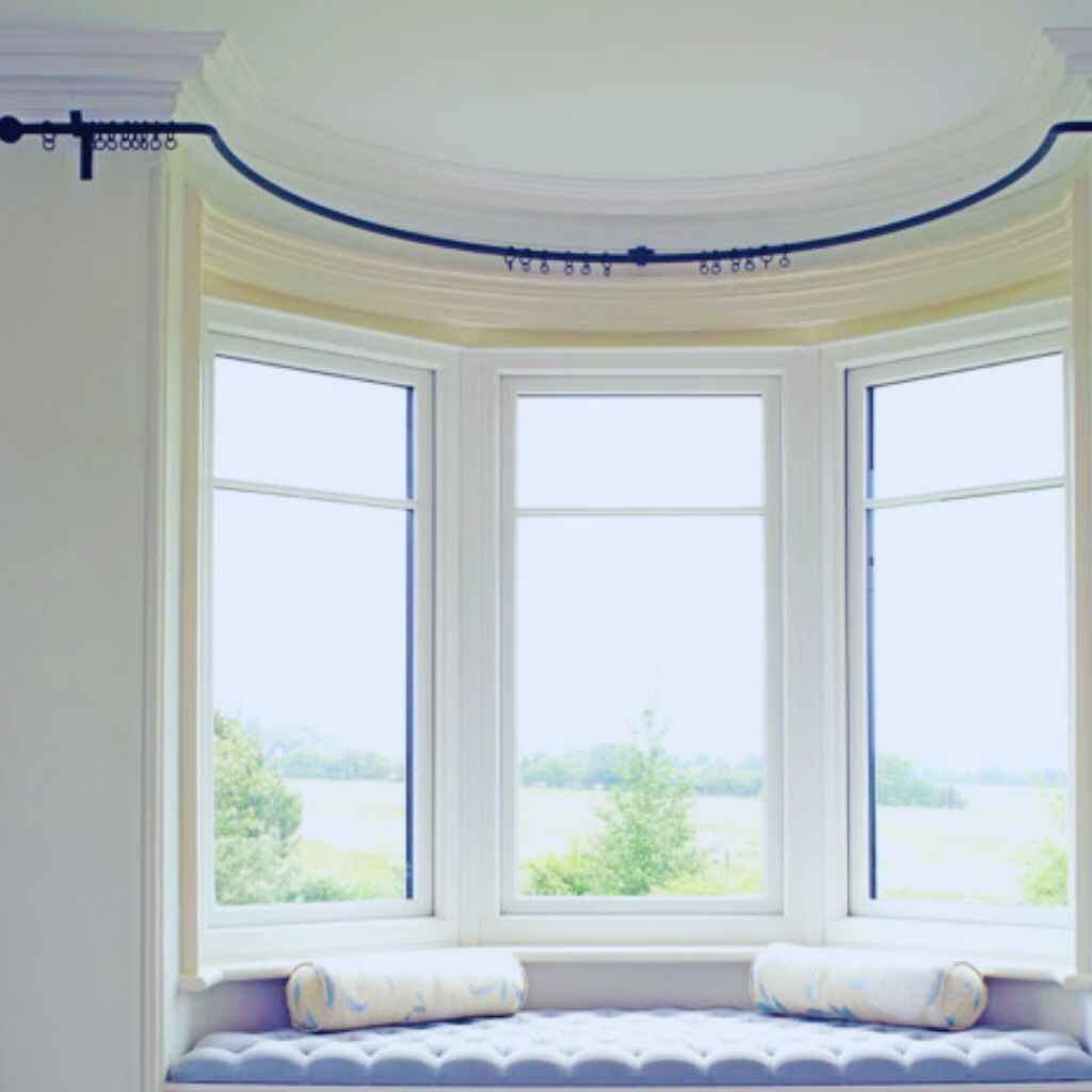 Curved curtain rods designed to fit a bay window, ensuring a smooth, tailored look.