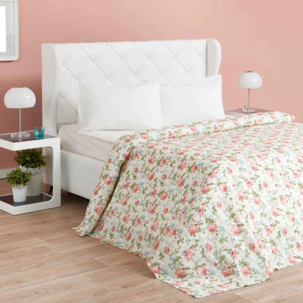 Floral pink bedsheets on a bed with nature-inspired decor.