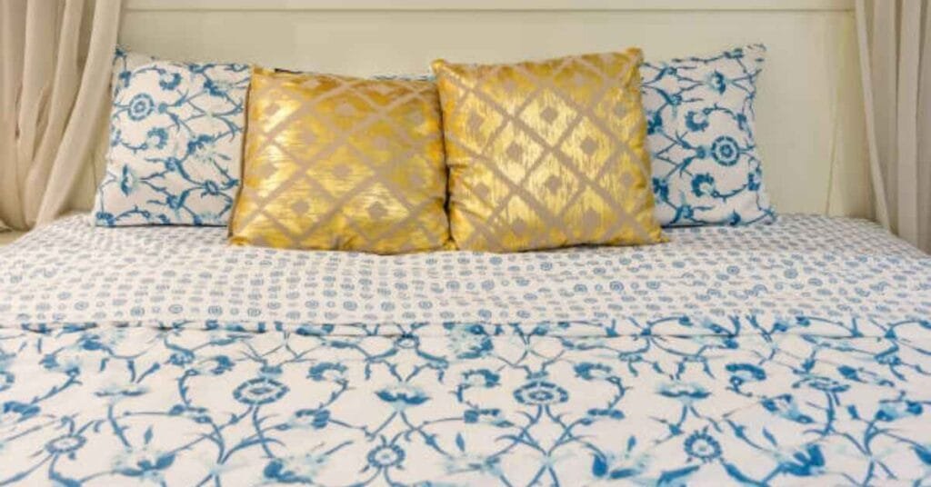 Patterned bed sheets adding style to a cozy bedroom.