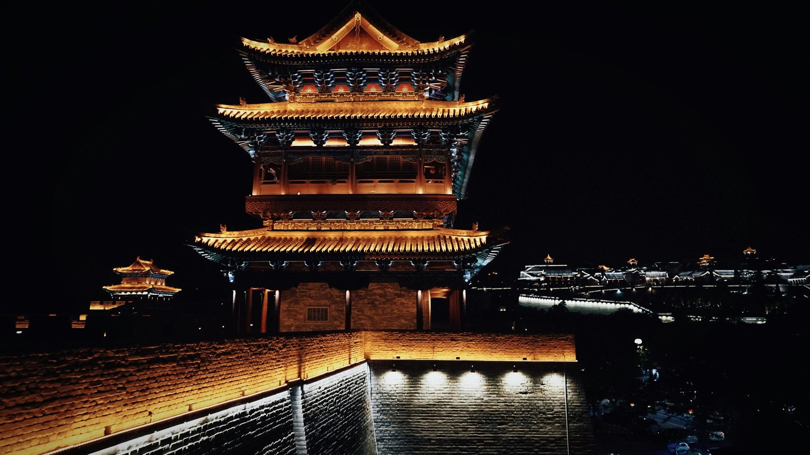 Majestic ancient Chinese tower illuminated against the night sky, showcasing traditional architecture.